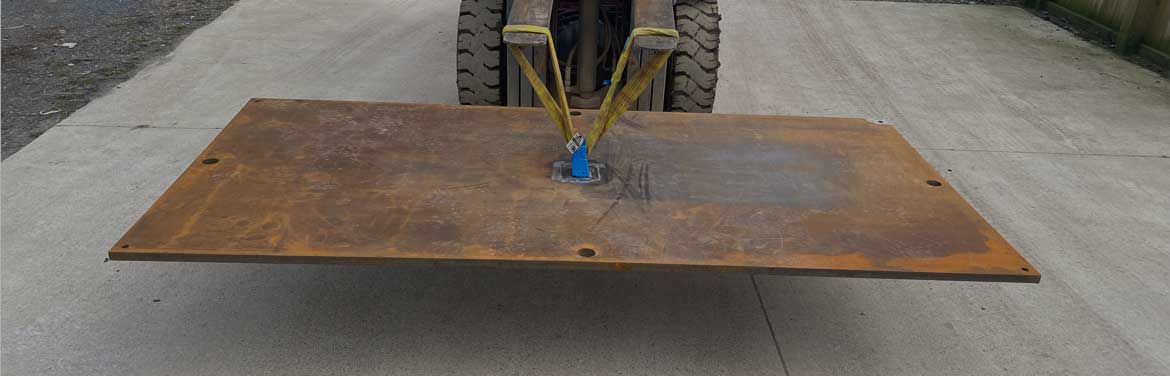 Steel trench cover being lifted by a forklift